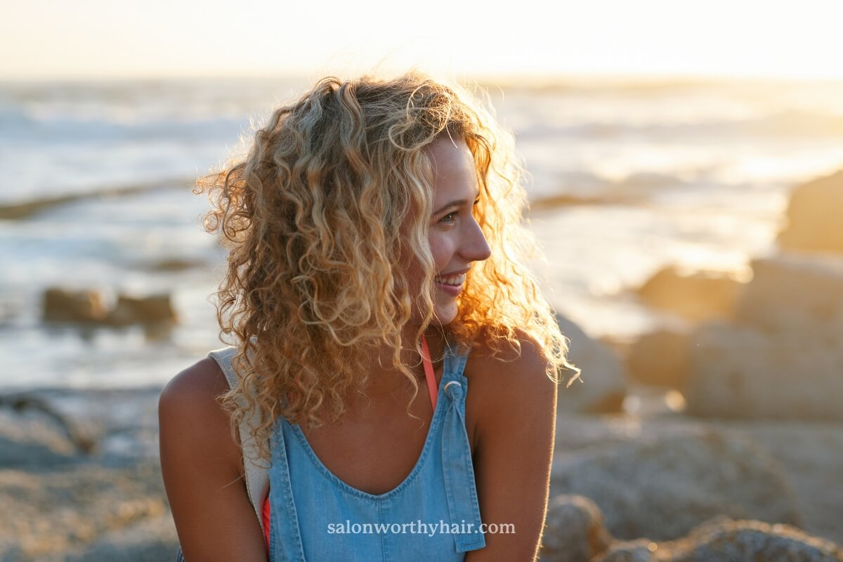 A woman with beachy waves in her hair,next to the ocean