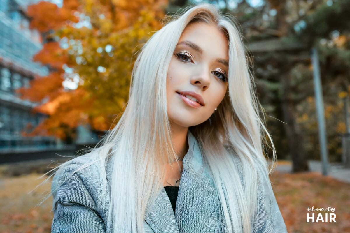 Icy blonde hair has shimmering silver undertones, devoid of warmth, with a reflective, frost-inspired luster.