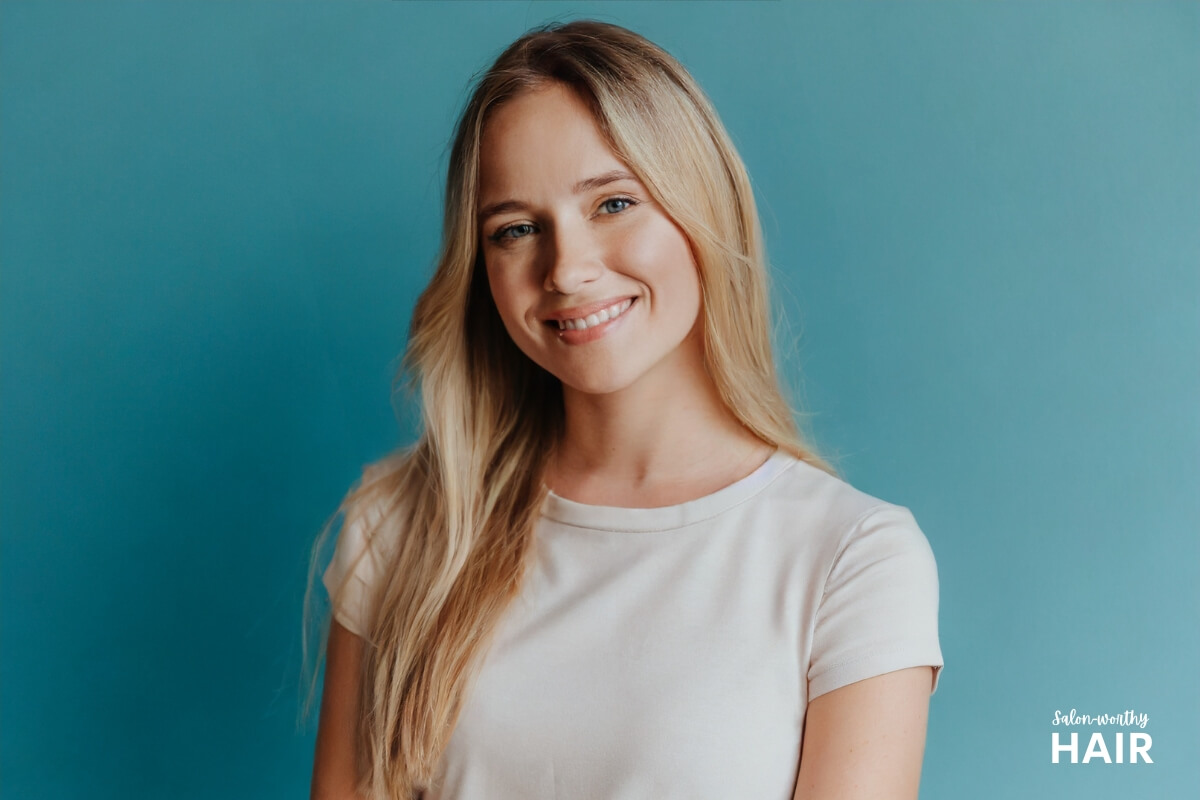 Rooted blonde has darker roots that seamlessly transitioning into lighter blonde lengths, mimicking natural hair growth.