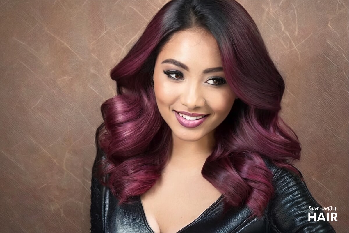 young woman with magenta hair dye on black hair showing her results